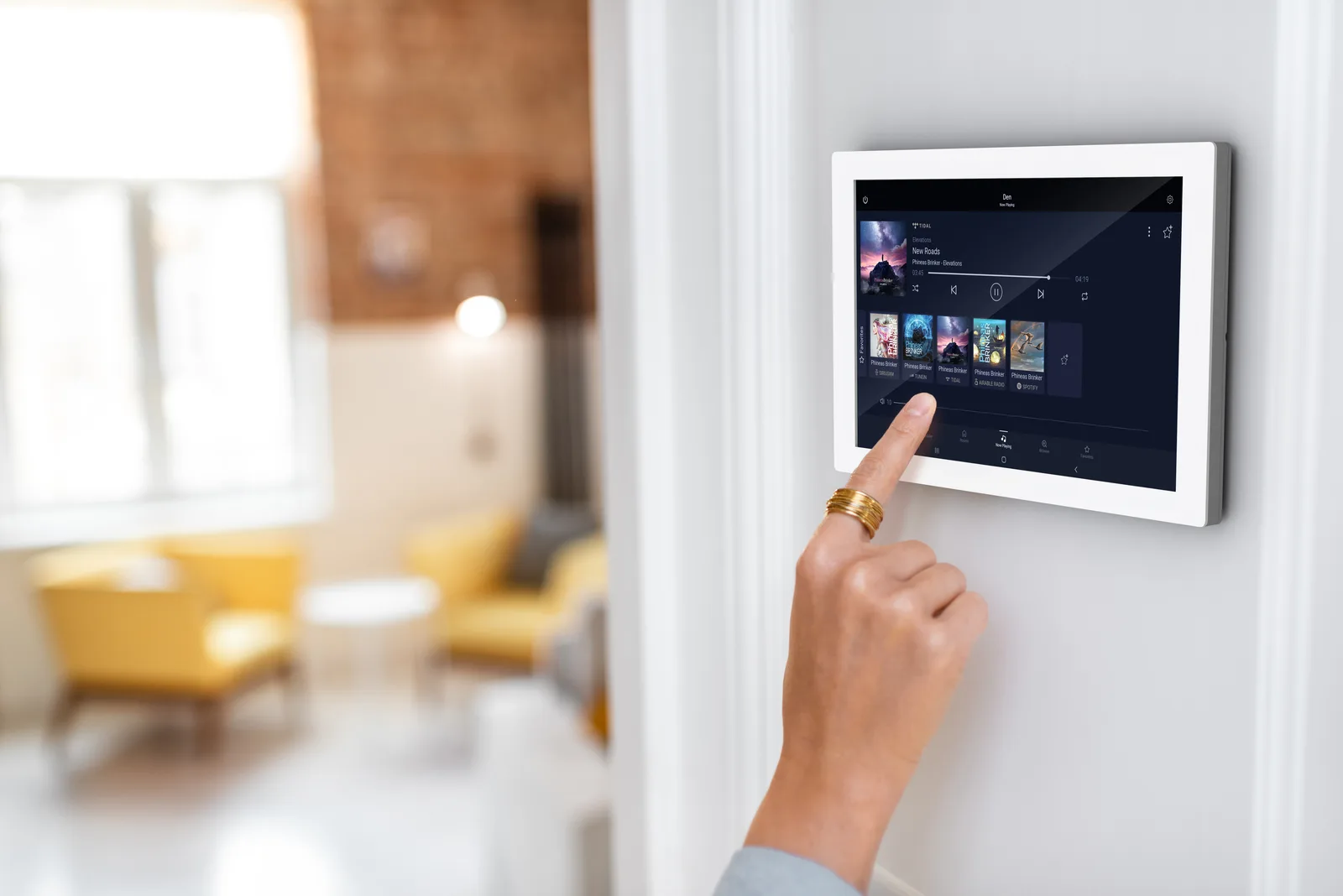 A person choosing music on a wall-mounted Russound XTS7 touchscreen
